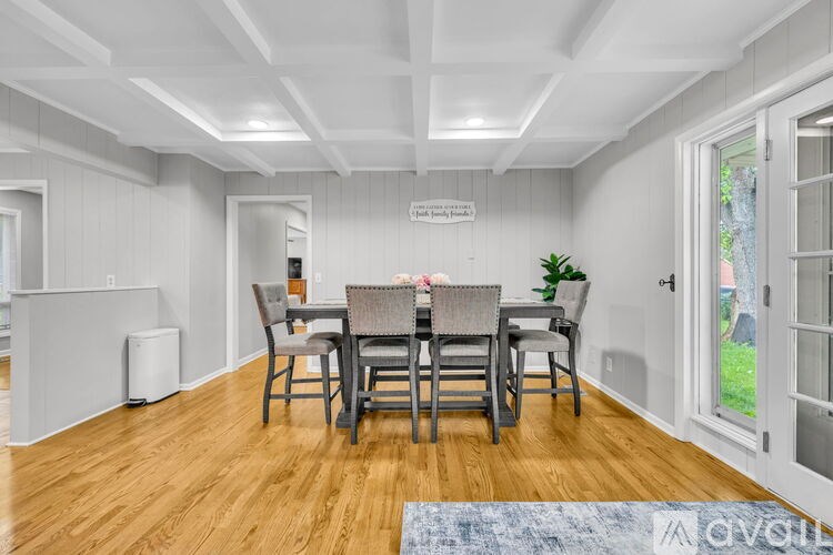 A dining room with a wooden floor and a white ceiling.