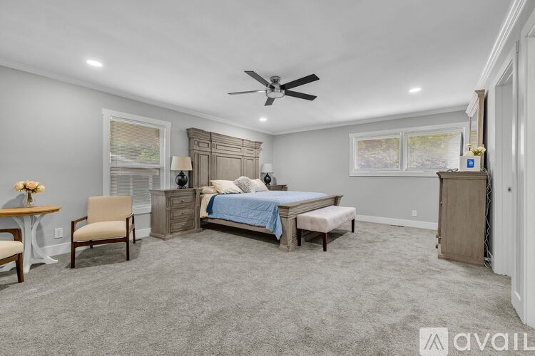 A bedroom with a bed, dresser, and chair.