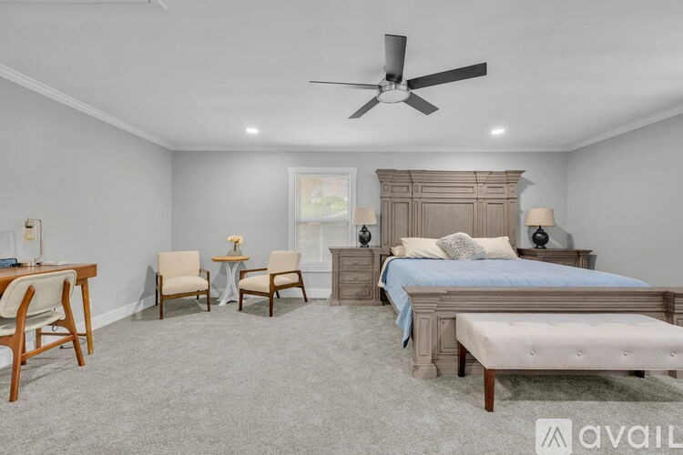 A bedroom with a large bed, a desk, and a chair.