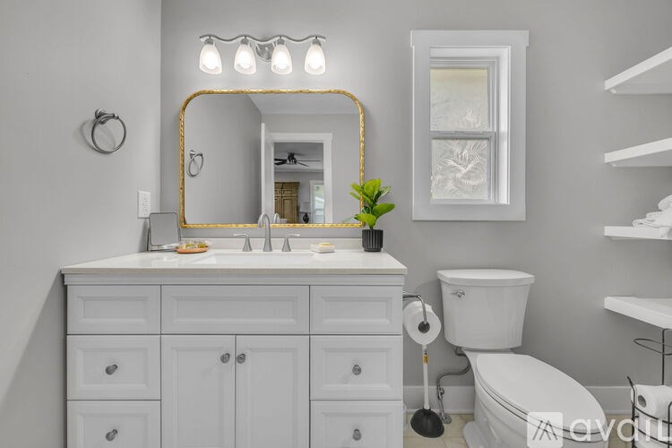 A bathroom with a white toilet, sink, and mirror.
