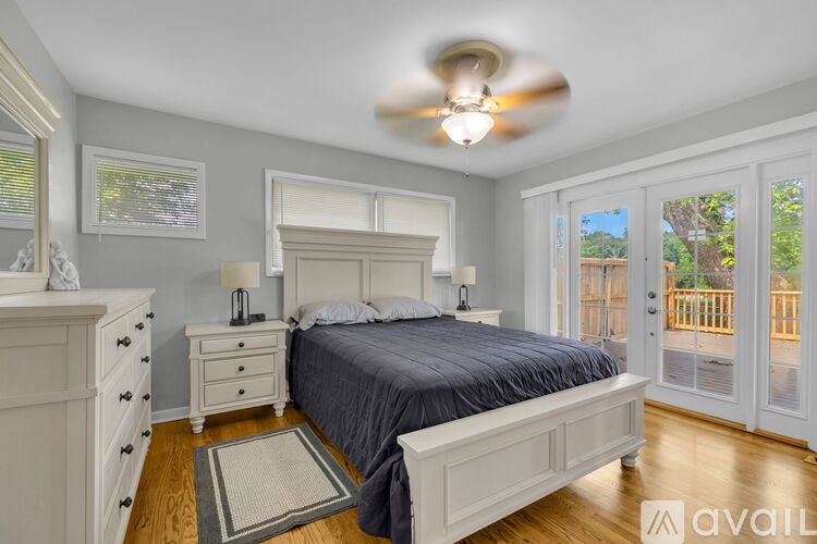 A bedroom with a bed, dresser, and ceiling fan.