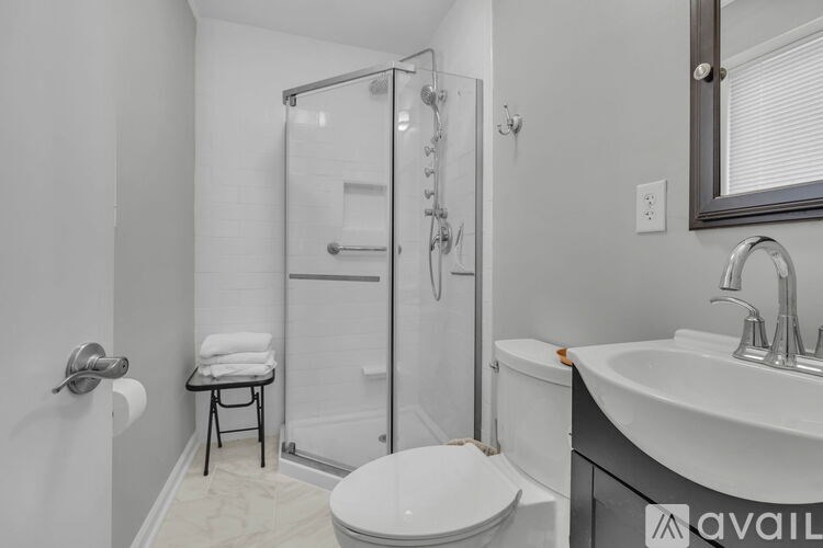 A bathroom with a toilet, sink, and shower.