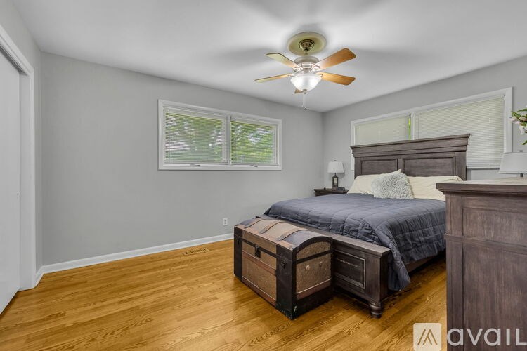 A bedroom with a bed, nightstand, and a ceiling fan.