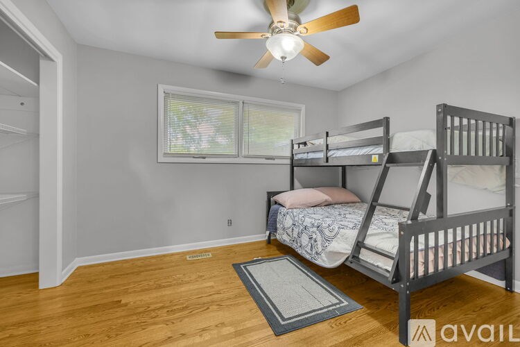 A room with a bunk bed and a ceiling fan.