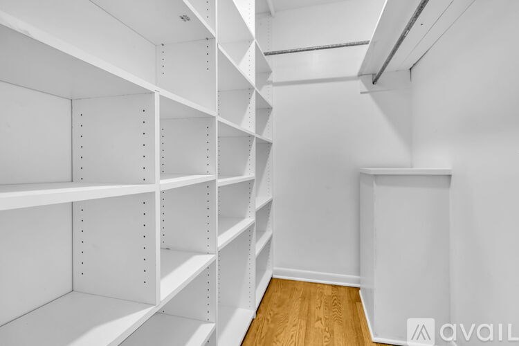 Empty white shelves in a room with wooden flooring.