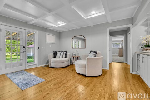 A living room with a white couch and a blue rug.