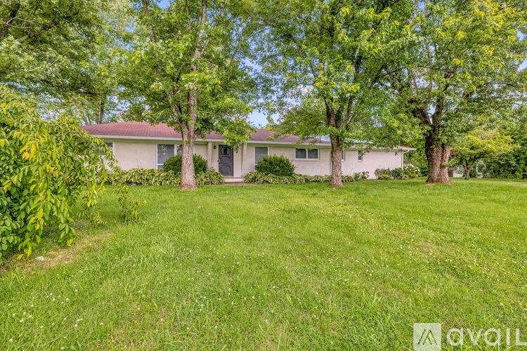 A house with a lawn and trees in front of it.