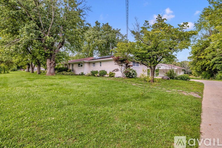 A house is surrounded by a grassy area and trees.
