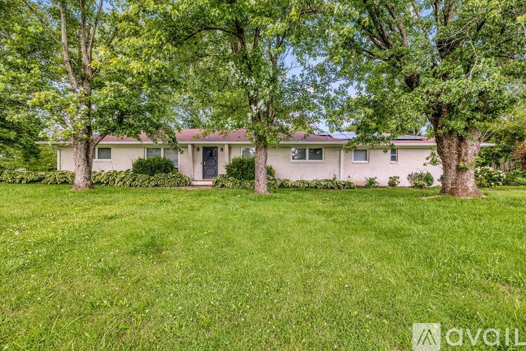 A house with a lawn and trees in front of it.