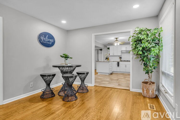 A room with a wall-mounted sign that says "Avon" and a potted plant on the floor.