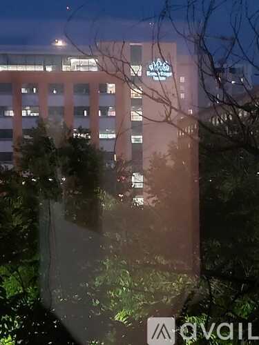 A building with a lit up sign that says "AVAIL" in front of it.