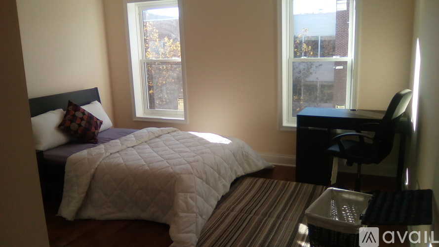 A bedroom with a bed, desk, and chair.