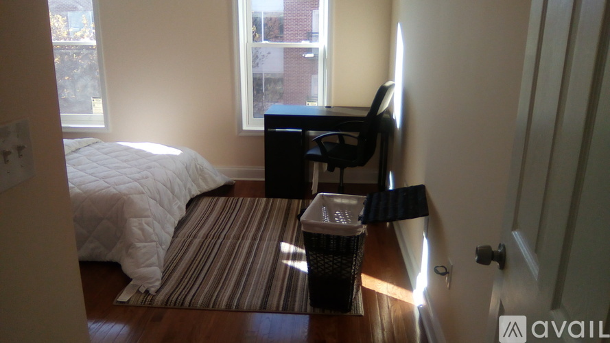 A room with a bed, a chair, and a desk.