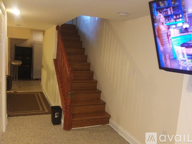 A staircase in a house with a television on the wall.