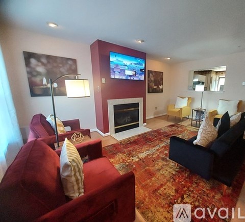 A living room with a red couch and a fireplace.