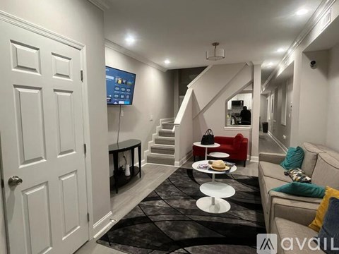A living room with a couch, a TV, and a staircase.