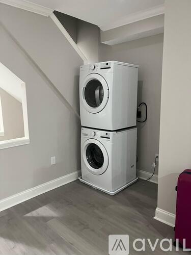A stacked washer and dryer in a laundry room.
