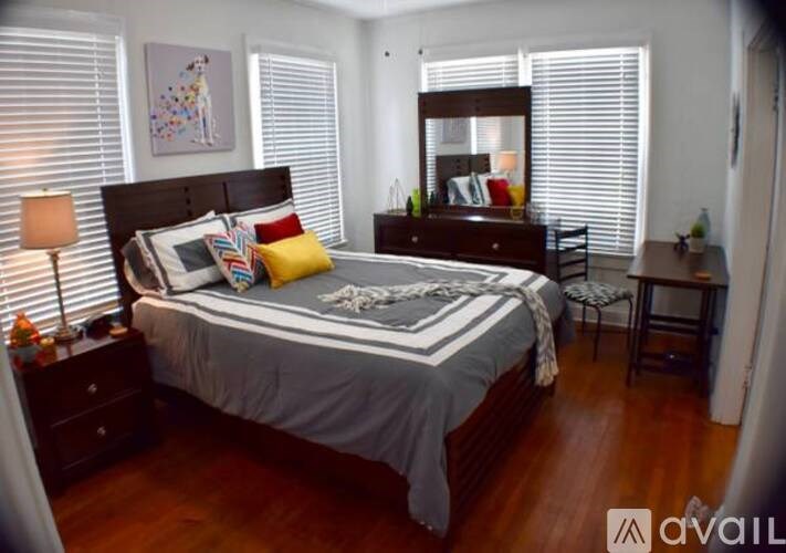 A bedroom with a large bed and a wooden dresser.