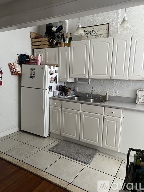 A white kitchen with a fridge and cabinets.
