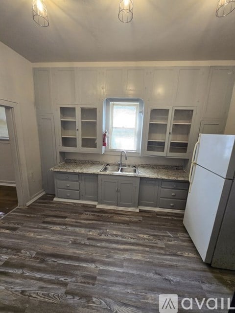 A kitchen with a white refrigerator and wooden cabinets.
