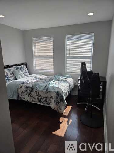 A bedroom with a bed, a chair, and a window.