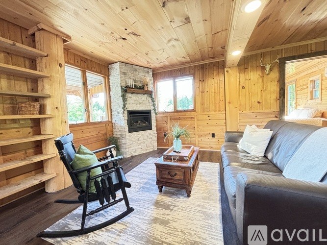 A cozy living room with a rocking chair and a fireplace.