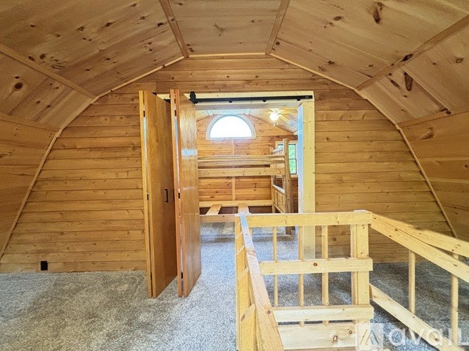 A wooden house under construction with a window and a door open.