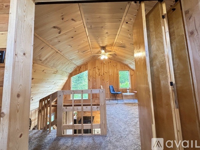 A wooden room with a window and a table in the middle.