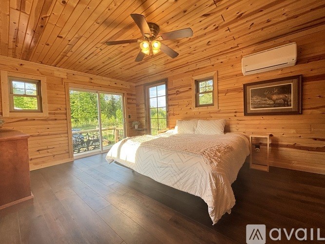 A bedroom with wooden walls and a bed in the center.