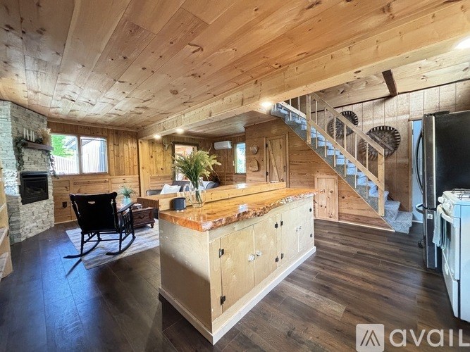 A wooden cabin with a staircase and a rocking chair.