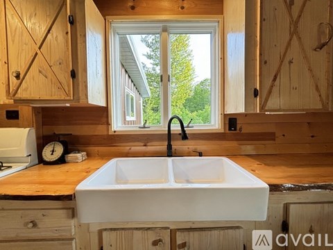 A white sink is in a wooden cabinet in a kitchen.