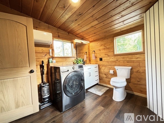 A small wooden cabin with a washer and dryer in it.