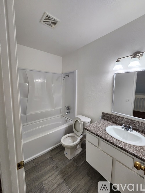A bathroom with a toilet, sink, and bathtub.