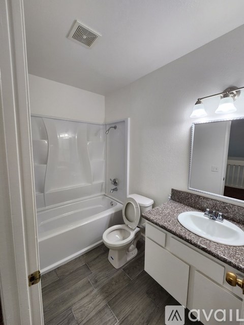 A bathroom with a toilet, sink, and bathtub.