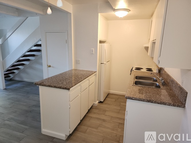 A kitchen with a granite countertop and white cabinets.