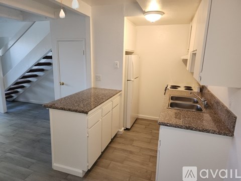 A kitchen with a granite countertop and white cabinets.