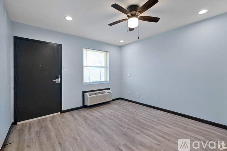 A room with a ceiling fan and a window with blinds.
