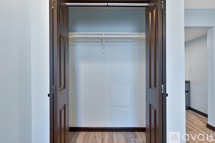 A white wall with a brown door and a white light switch.