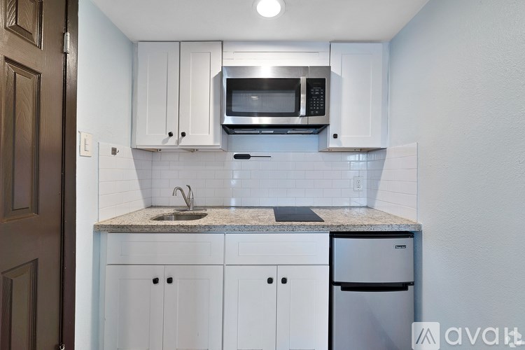 A kitchen with white cabinets and a granite countertop.