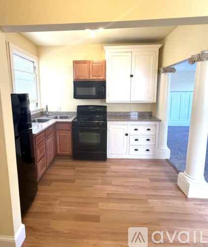 A kitchen with wooden cabinets and black appliances.