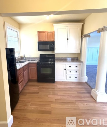 A kitchen with wooden cabinets and black appliances.