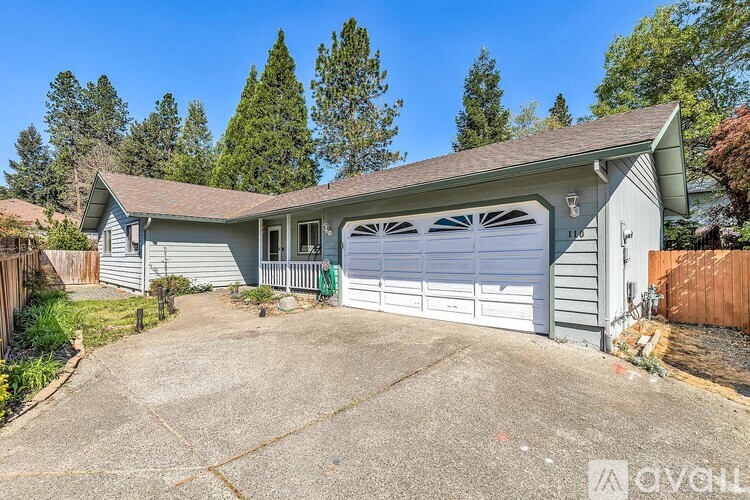 A house with a garage and a driveway in front of it.