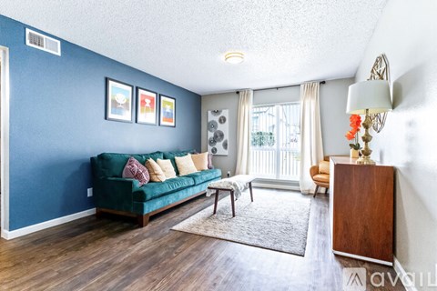 A living room with a green couch and a wooden cabinet.