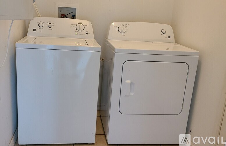 Two white appliances, a dryer and a washing machine, are placed next to each other.