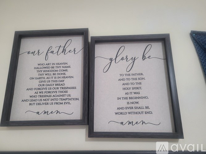 Two framed religious texts titled "Our Father" and "Glory Be" are displayed on a wall.