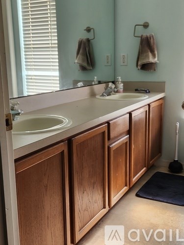 A bathroom with two sinks and wooden cabinets.