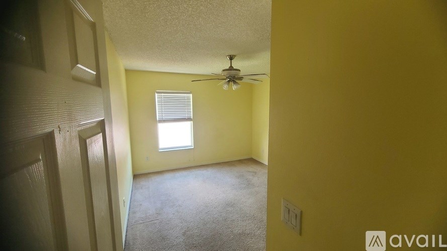 A room with a ceiling fan and a window.