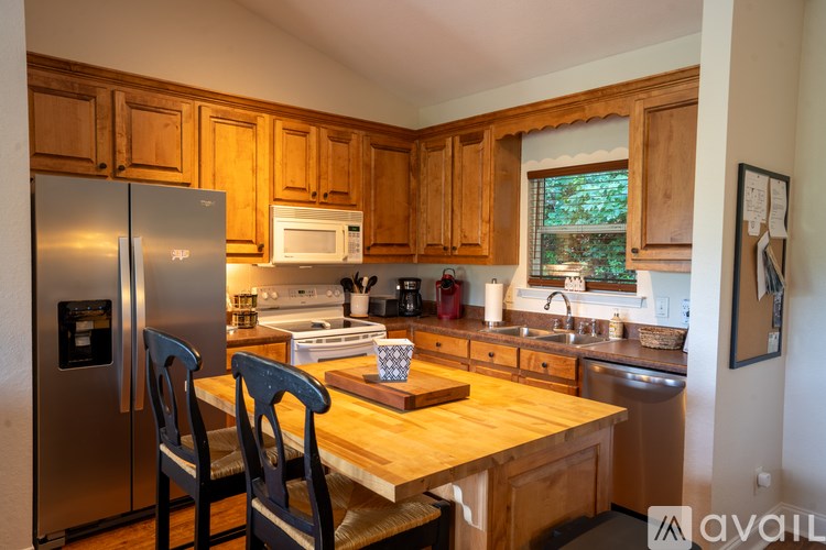 A kitchen with wooden cabinets and a stainless steel refrigerator.