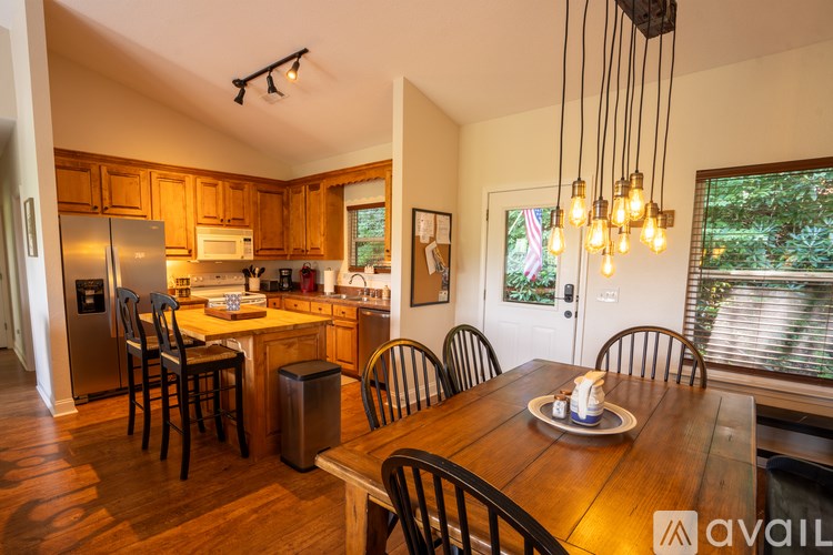 A kitchen with wooden cabinets and a dining table with chairs.