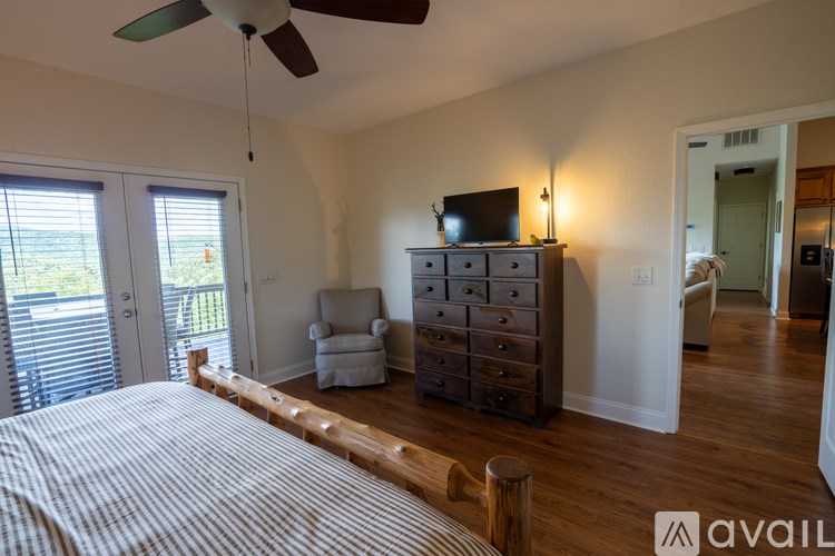 A bedroom with a bed, dresser, and sliding glass doors.
